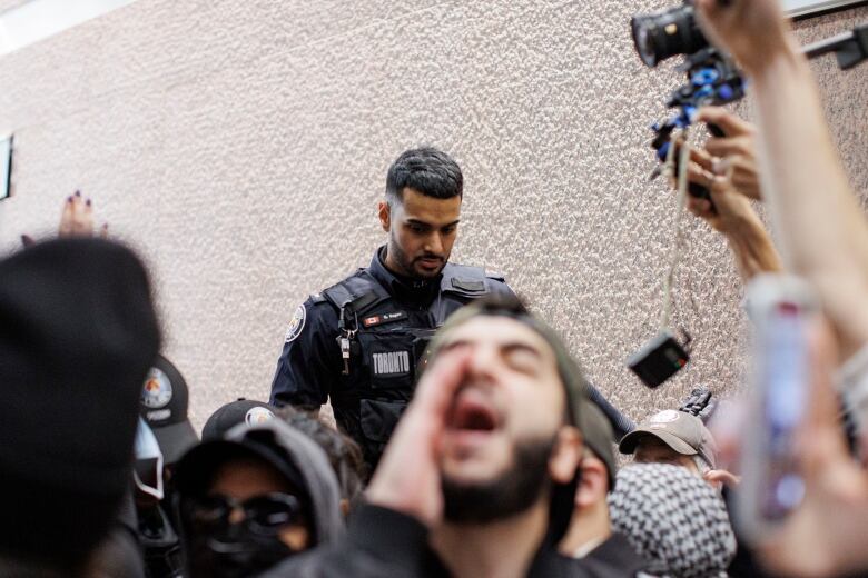 A cop is seen behind demonstrators.