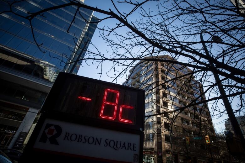 A sign showing 8 C is pictured beneath high skyscrapers.