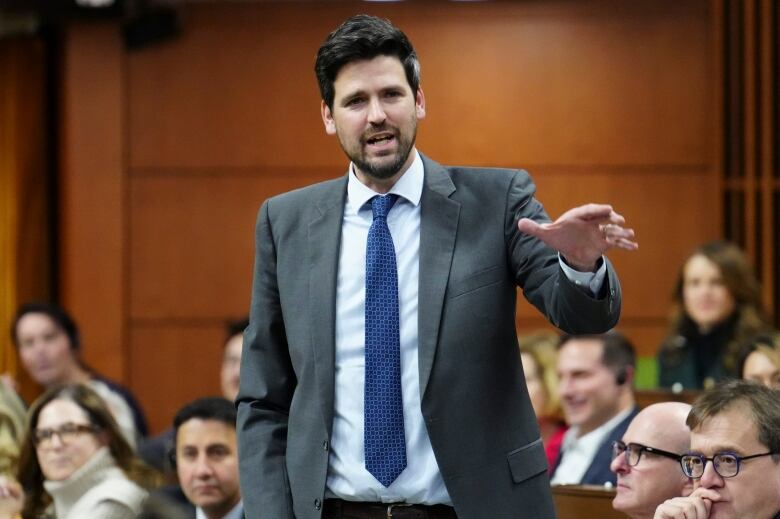 A man in a gray suit speaks in the House of Commons.