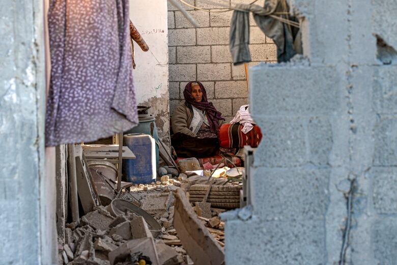 A woman is seen sitting inside a damaged home in the Gaza Strip community of Rafah.