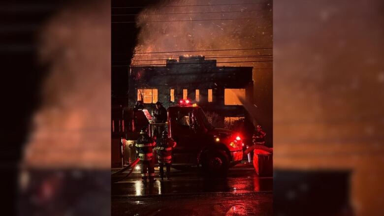 a burning building with fire crews in front 