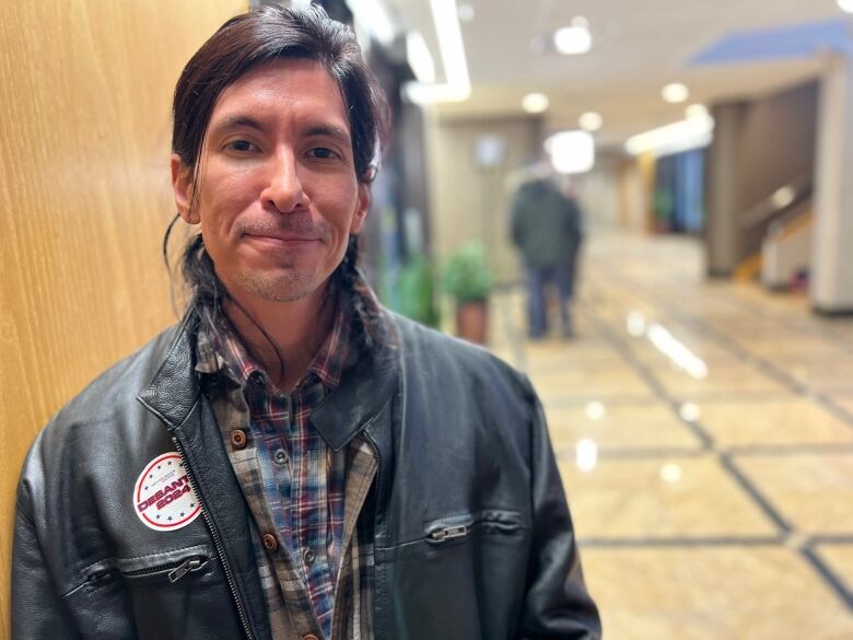 Man leans against wall with DeSantis button on leather jacket