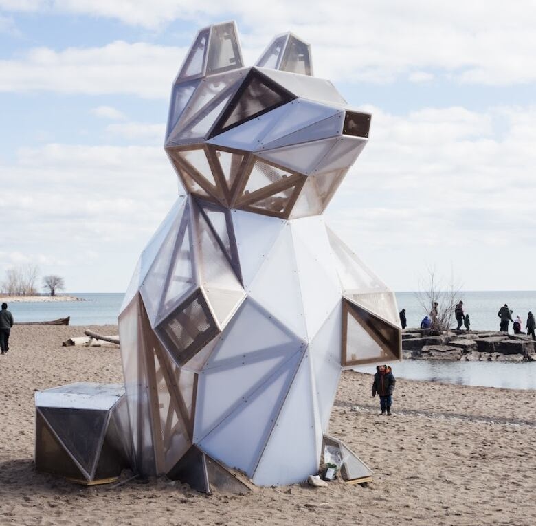 An art exhibit of a raccoon on a beach.