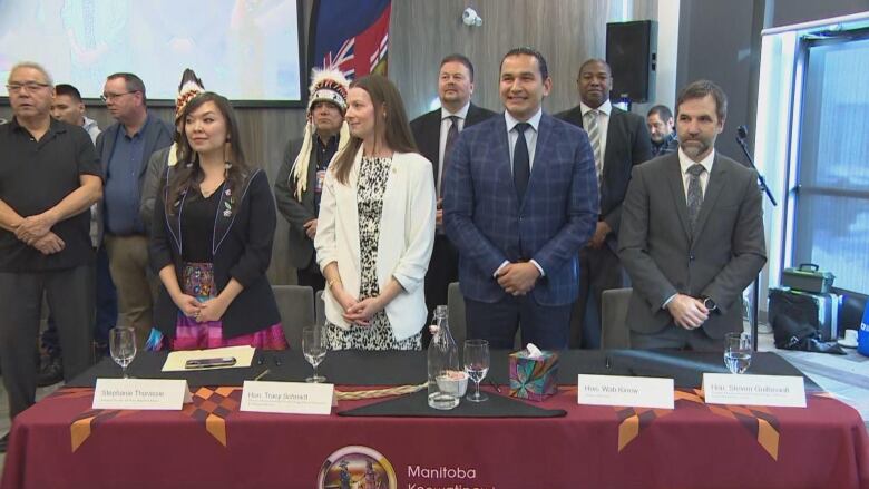 A group of people standing behind a table.