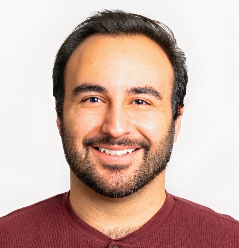 A man is seen smiling at the camera in a close-up shot.