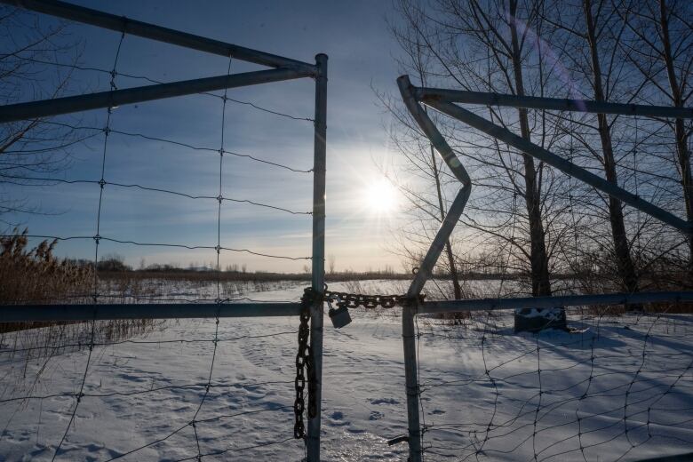 A fence in front of a large field.