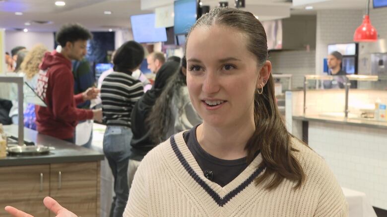 a young woman wearing a white sweater.