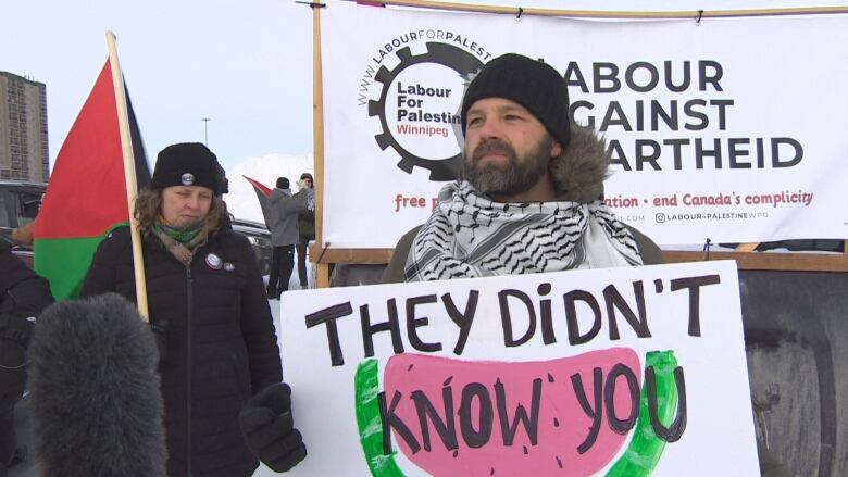 A man holds up a sign.