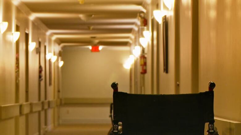 A wheelchair sits in a hallway.