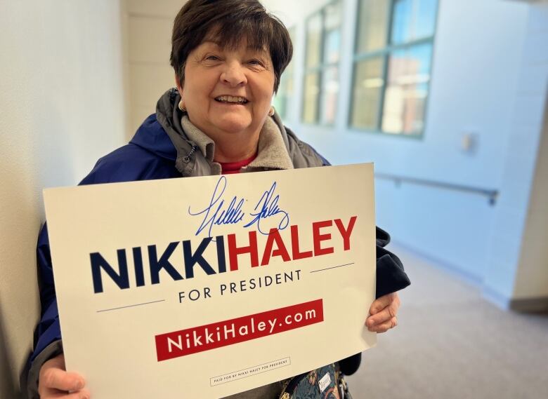 Woman holds autographed Haley sign