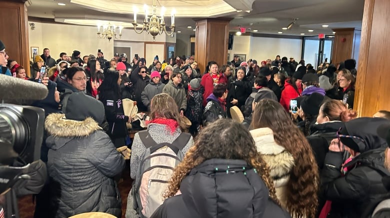 A large crowd gathers in a hotel.