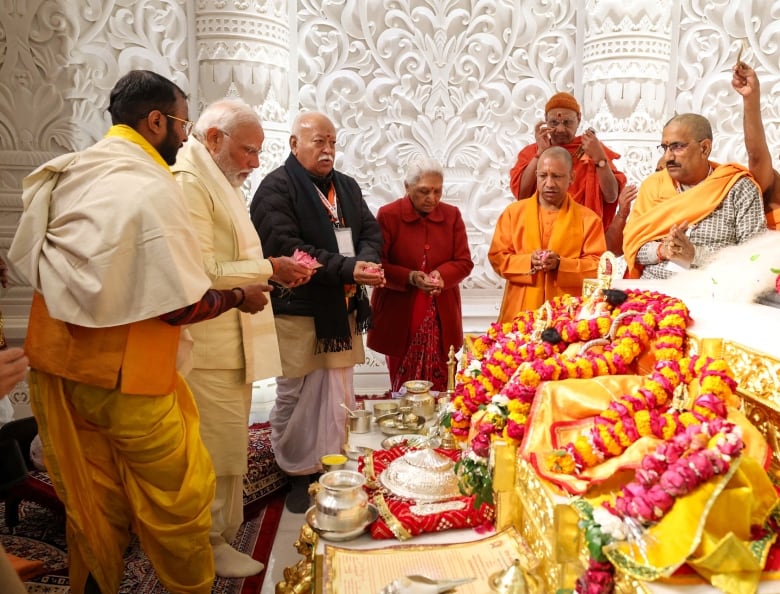 People stand at the opening of a temple in Ayodhya, India.