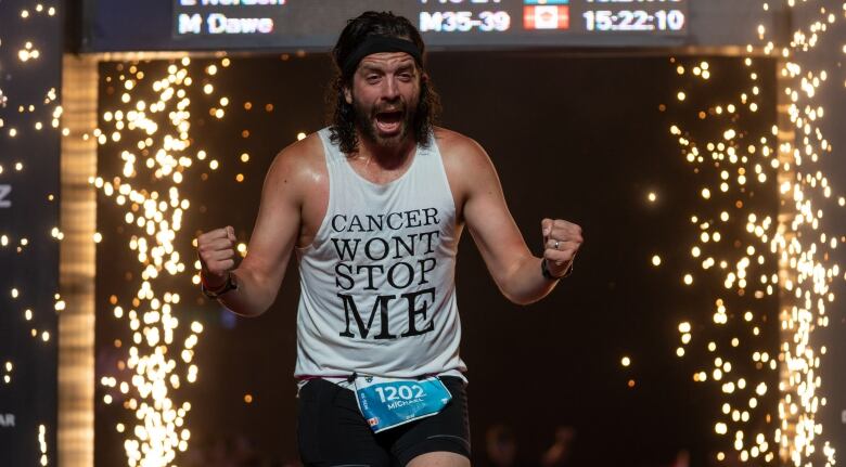 Mike Dawe fishing an Ironman triathlon last year in Kalmar, Sweden. He is wearing a black headband and a tank-top that says 