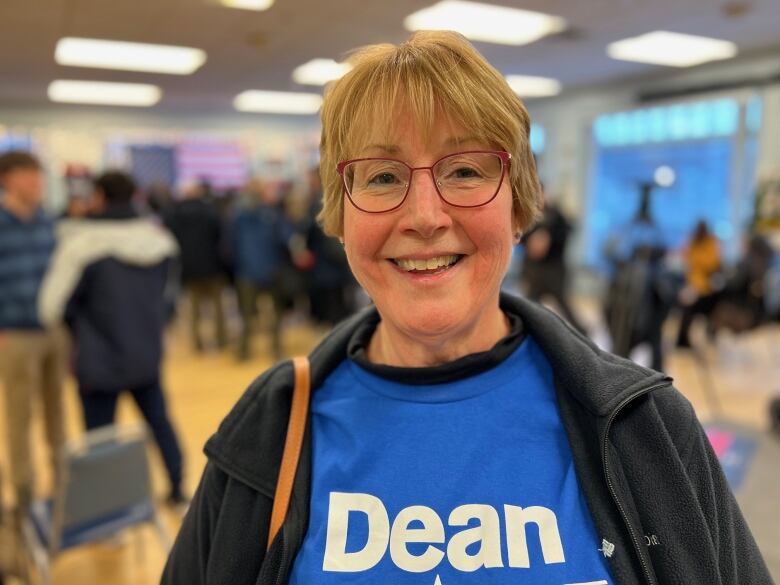 Woman in glasses and T shirt that says Dean.