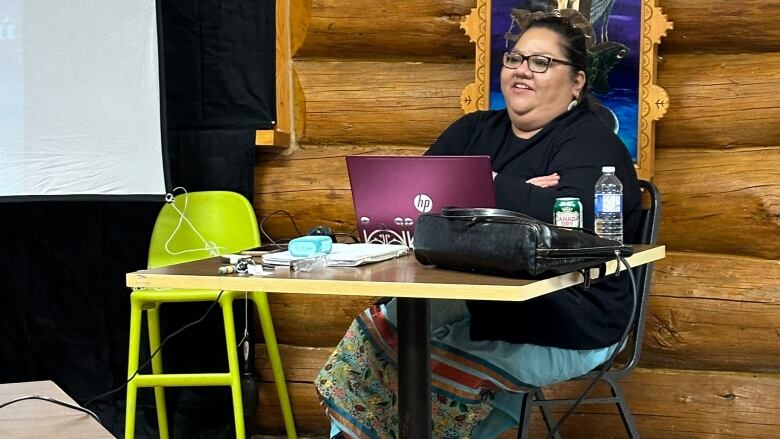 Woman presenting at front of the room.