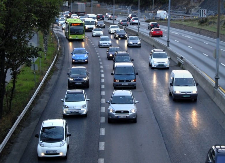 This August 19, 2014 picture shows electric cars crowding the bus lane (L) during the morning rush hour towards Oslo at Hoevik on E-18.