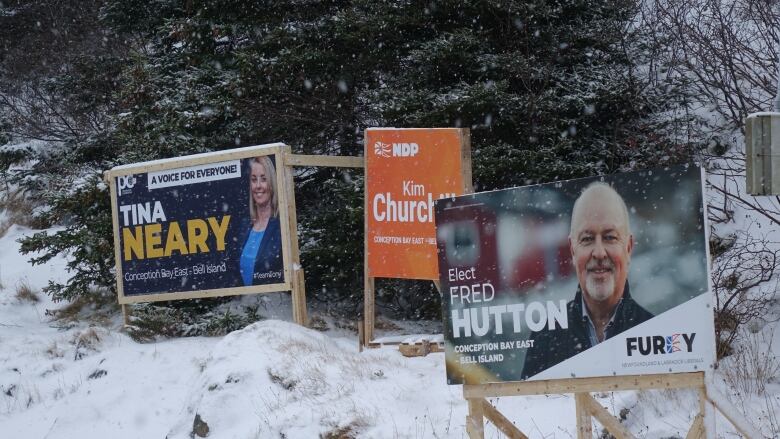 Election signs staked in a snow covered bank. 