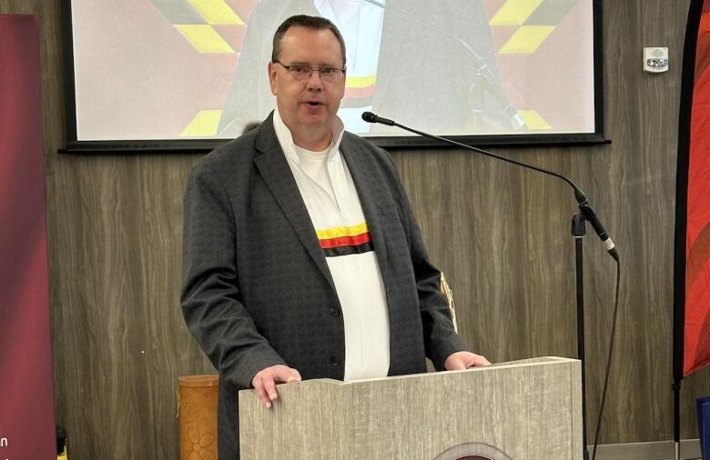 A man speaks at a podium.