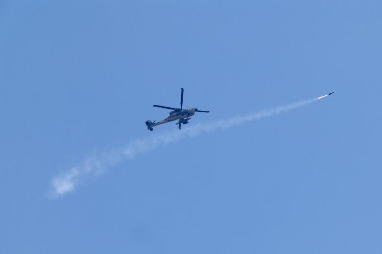 A missile is seen firing from an Israeli military helicopter, at a position along the Gaza Strip.