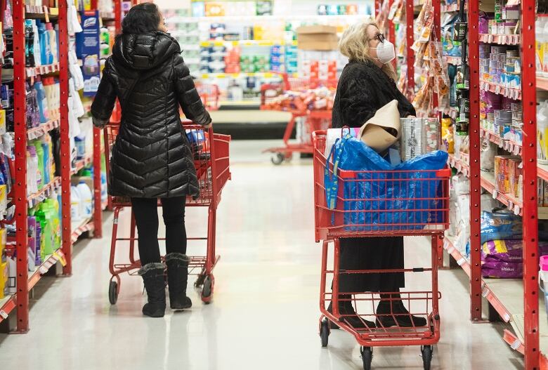 Two people shop in a grocery store.