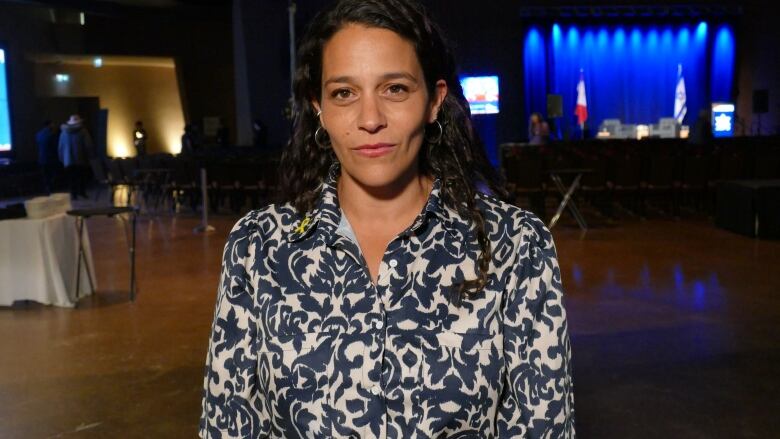 A woman in a patterned shirt poses for the camera.