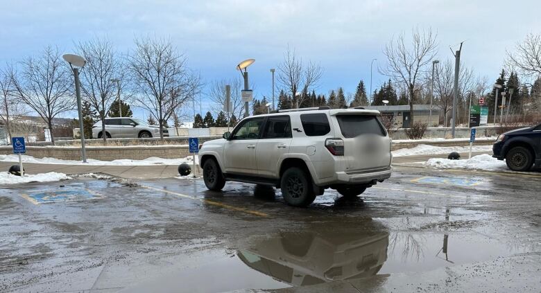 a row of accessible parking stalls with a white vehicle parked in front.