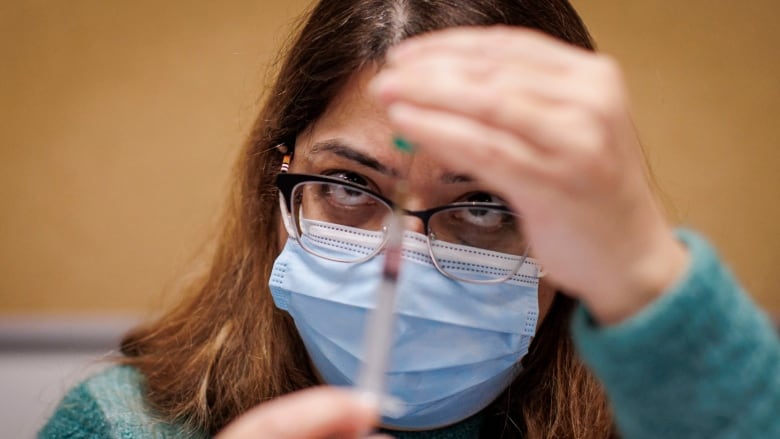 A Toronto Public Health nurse prepares a vaccine. 