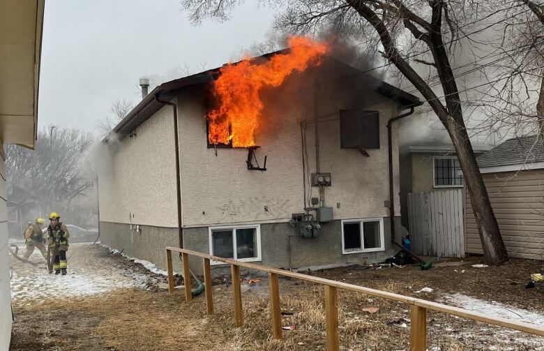 House with fire coming out of back window.