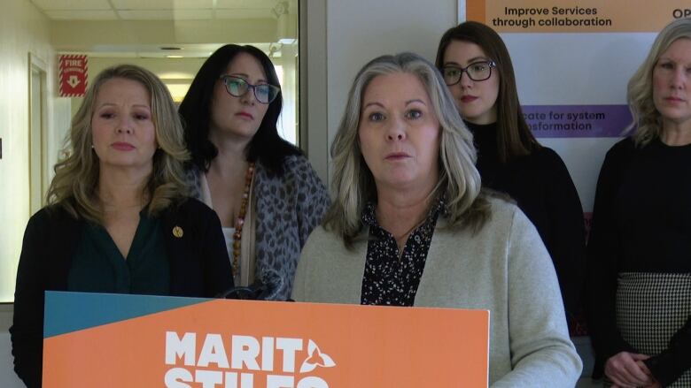 A woman stands at a podium