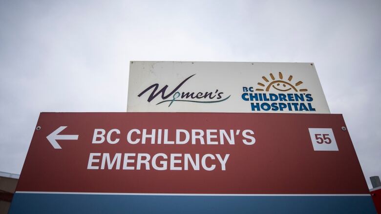 A sign pointing left reads 'BC Children's Emergency', with a sign above it having the logos for the B.C. Women's Hospital and B.C. Children's Hospital.