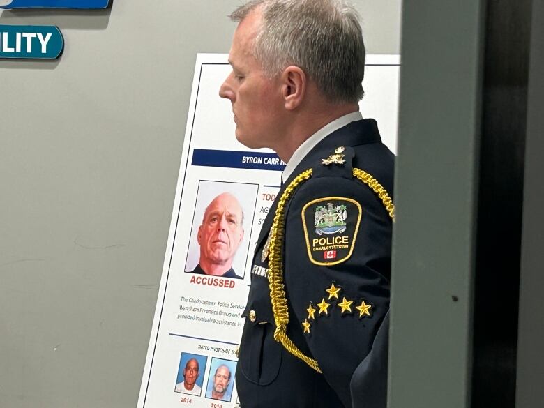 Charlottetown Police Chief Brad MacConnell stands in front of a poster showing an image of Todd Joseph Gallant, now charged with 1st-degree murder in the Byron Carr case. 