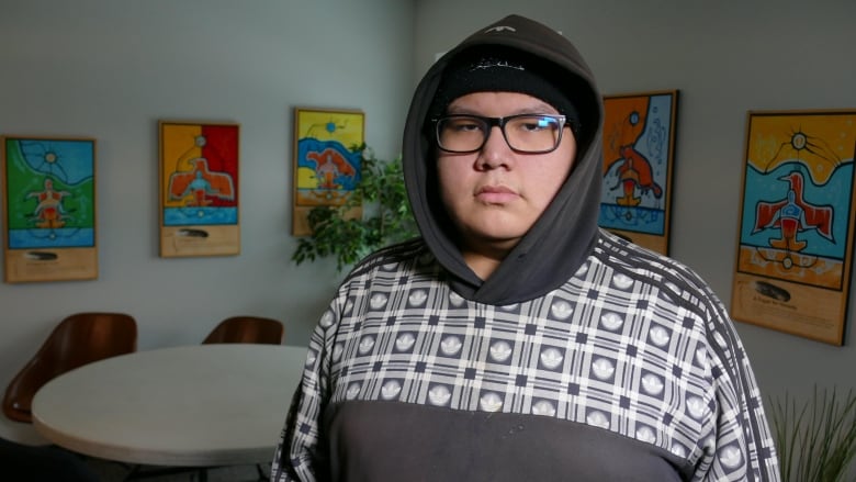 A boy in a black and white hoodie wearing glasses