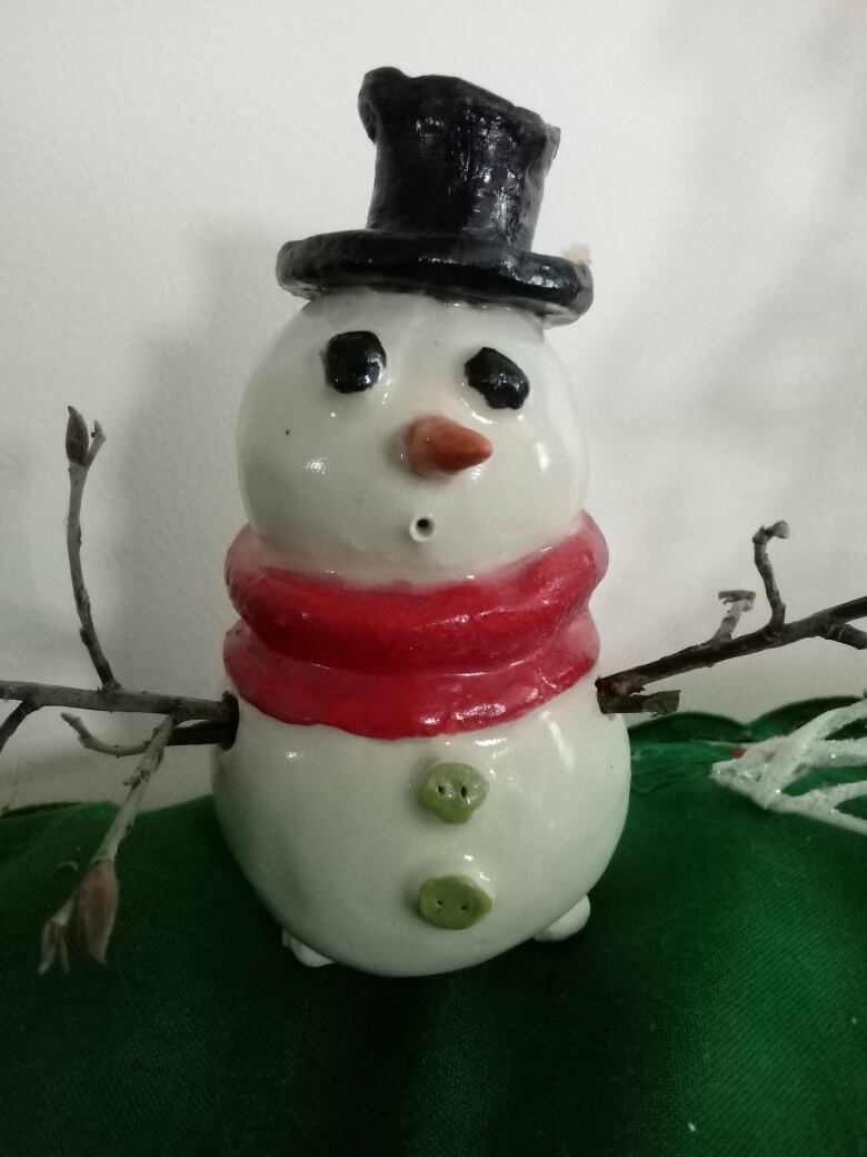 A picture of a snowman made out of pottery. 