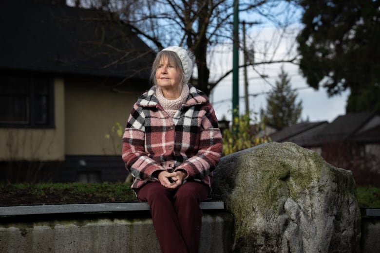 An older white woman wearing a toque smiles.