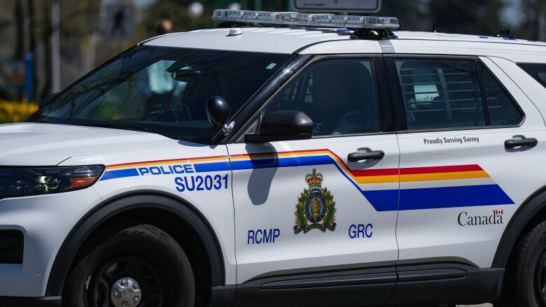 A police vehicle marked 'RCMP GRC' lies on a street.