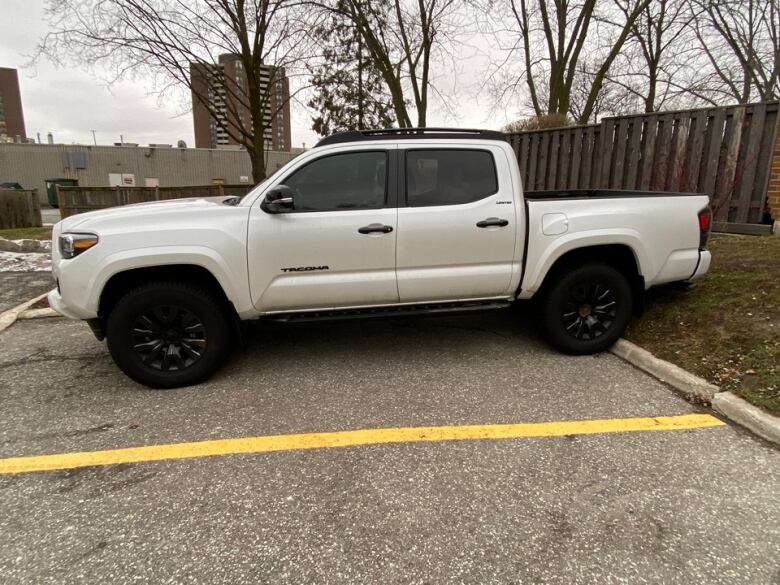 A white Toyota Tacoma sits in a parking lot.