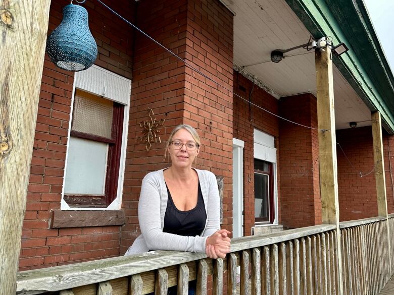 woman stands at balcony