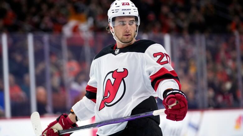 Hockey player on the ice holding a hockey stick.