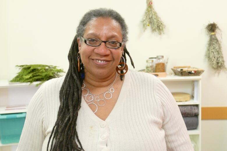 A woman in a white button up dress and glasses