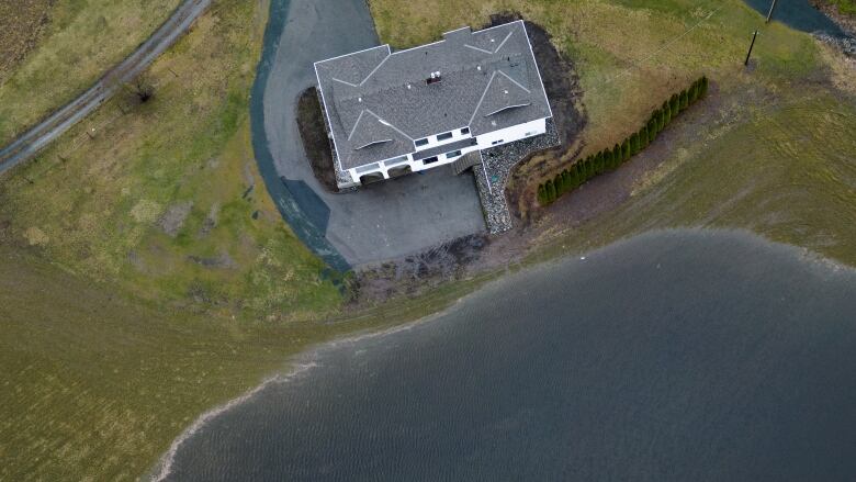 An aerial photo shows floodwater near a farm house.