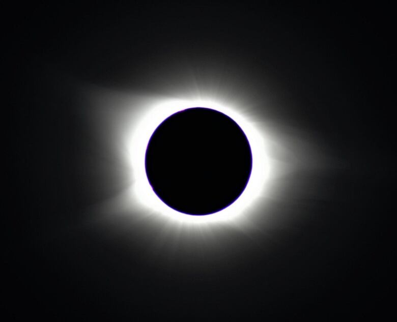 A black and white photo of a total solar eclipse. 