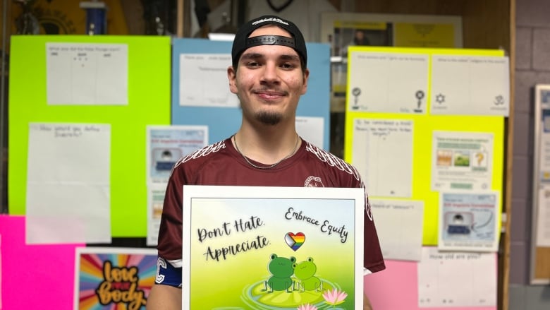 A teenage holds a poster with the message 