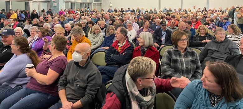 A large crowd of about 350 people filling a conference room