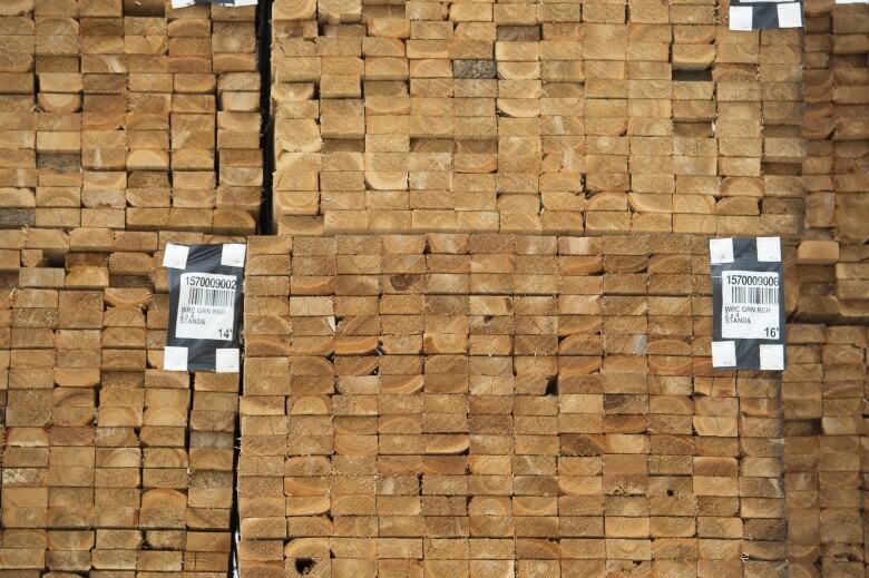 Fresh cut lumber is pictured stacked at a mill.