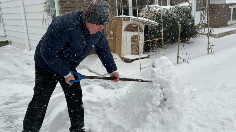 Man shovels snow in Moncton