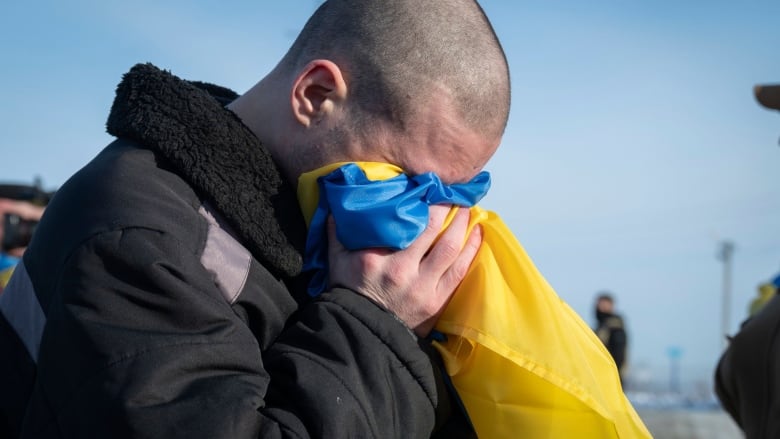 This photograph shared by the Ukrainian President Volodymyr Zelenskyy on the social media platform X on Wednesday, Jan. 31, 2024, shows Ukrainian prisoners of war react after a prisoner exchange at an undisclosed location, Ukraine. Russia and Ukraine have exchanged about 200 prisoners of war each, the countries said Wednesday, despite tensions stemming from last week's crash of a military transport plane that Moscow claimed was carrying Ukrainian POWs and was shot down by Kyiv's forces. 