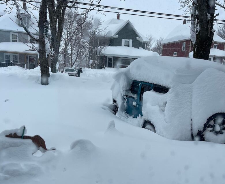 A jeep is covered in snow. 