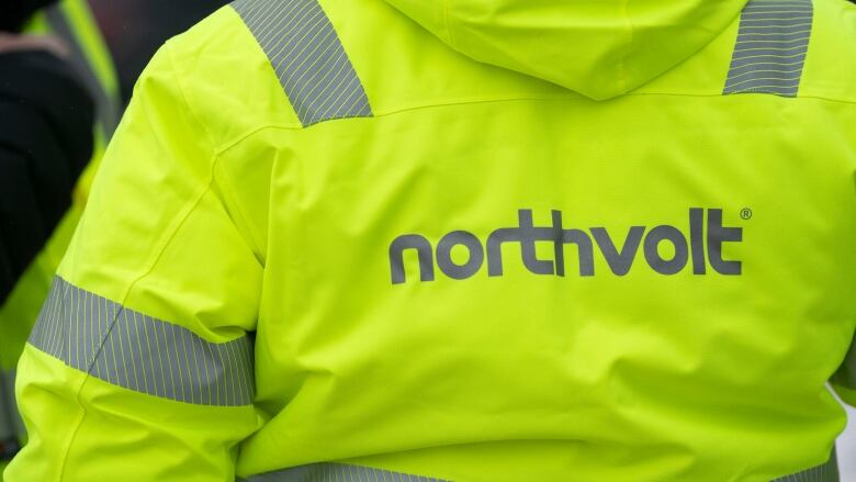 A neon yellow-green safety jacket with silver reflective stripes and the word northvolt on the back.