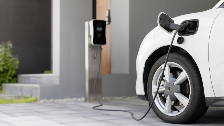 A car is seen plugged into an electrical outlet.