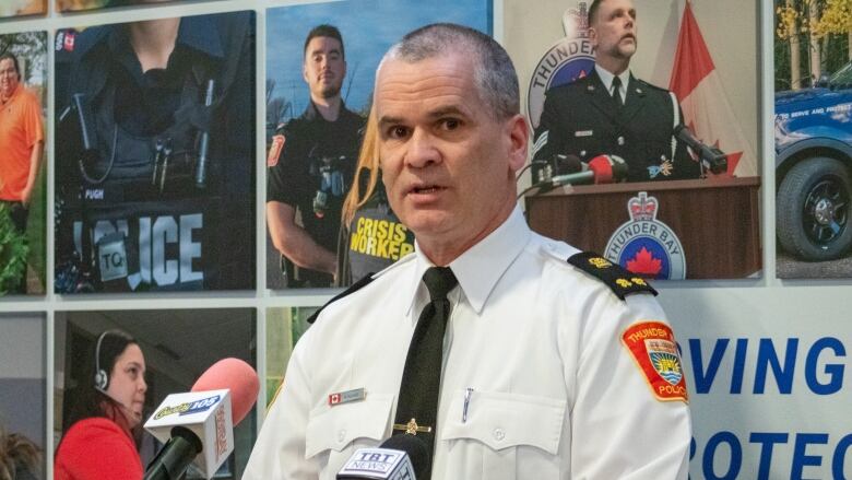 A person in a police officer uniform speaks at a podium.